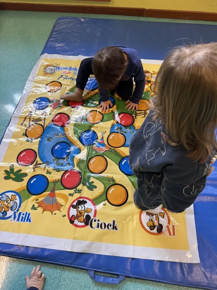 Due bambini che giocano insieme su un tabellone da gioco a terra